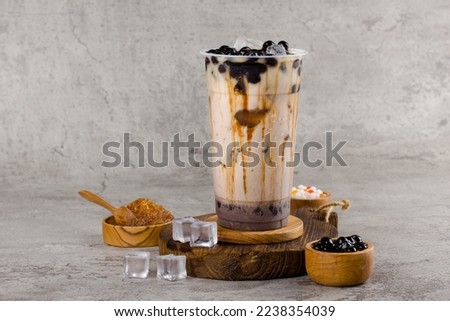 Boba or tapioca pearls is taiwan bubble milk tea in plastic cup with coffee latte flavor on texture  background, summers refreshment. Royalty-Free Stock Photo #2238354039