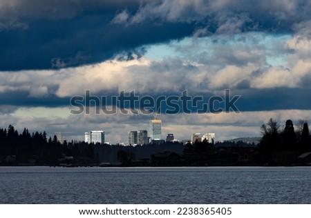 A view of downtown Bellevue near Seattle gleaming in sunshine with moody dark sky