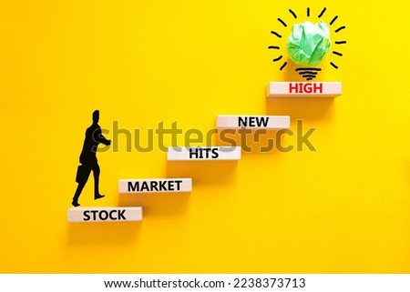 Stock market hits new high symbol. Concept words Stock market hits new high on wooden blocks on a beautiful yellow background. Businessman icon. Business stock market hits new high concept. Copy space