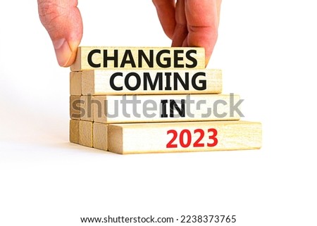 Changes coming in 2023 symbol. Concept word Changes coming in 2023 on wooden blocks. Businessman hand. Beautiful white table white background. Business and changes coming in 2023 concept. Copy space.