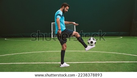Cinematic image of a soccer freestyle player making tricks with the ball on a artificial grass court indoor. Concept about sport and people lifestyle	 Royalty-Free Stock Photo #2238378893