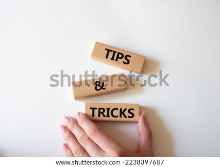 Tips and tricks symbol. Wooden blocks with words Tips and tricks. Beautiful white background. Businessman hand. Business concept and Tips and tricks. Copy space.