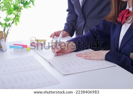 A girl studying and a teacher who teaches next to her.

The notes are written in English and their translations in Japanese. Royalty-Free Stock Photo #2238406983