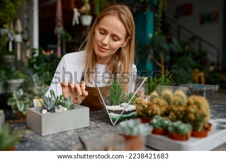 A woman making composition in florarium vase