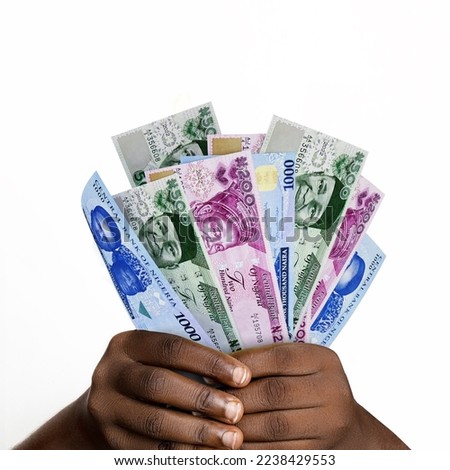 Black hands holding new 3D rendered Nigerian naira notes. closeup of Hands holding various Nigerian currency notes Royalty-Free Stock Photo #2238429553