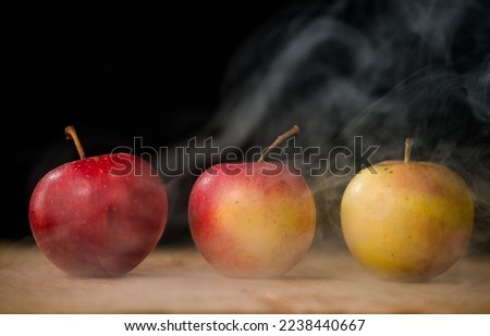 apples like magic in the smoke fresh apples on the table on a dark background filled with magic smoke