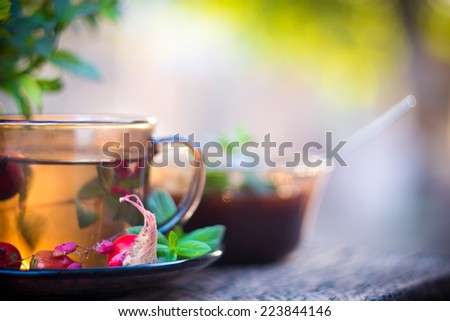 Autumn tea in black glass cup on old grey rustic wooden table