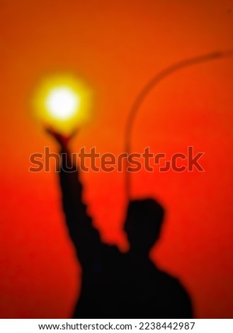 defocused abstract background of the shadow of a man holding the sun