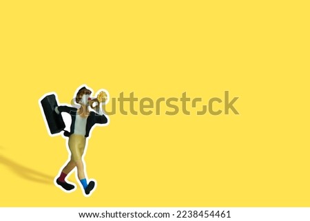 Miniature people toy figure photography. A clown wearing black suit and hat blow the trumpet on yellow background. Image photo
