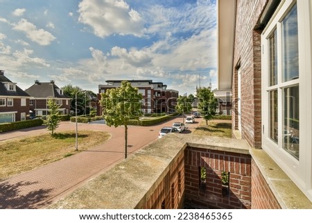 Panoramic view of old brick buildings with parking and trees from small balcony