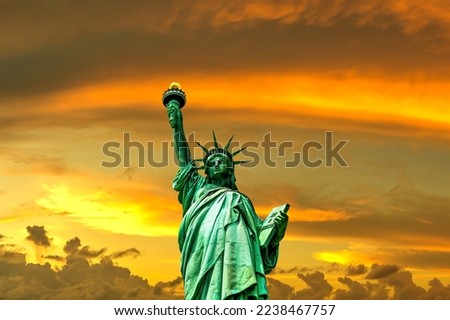 Statue of Liberty against sunset sky with beautiful cloud background in New York City, NY, USA