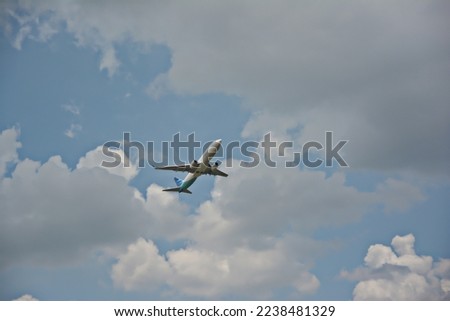 take a picture of an airplane flying over a bright cloud