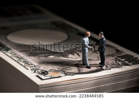 Miniature doll businessman  and Japanese 10,000 yen bill.
Businessmen are having business negotiations. Royalty-Free Stock Photo #2238484585