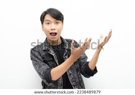 Young asian man open arms and hands palm to present something. proud Asian man with a smile offers and presents an advertisement