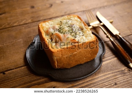 Bread hollowed out and filled with gratin sauce and baked. 