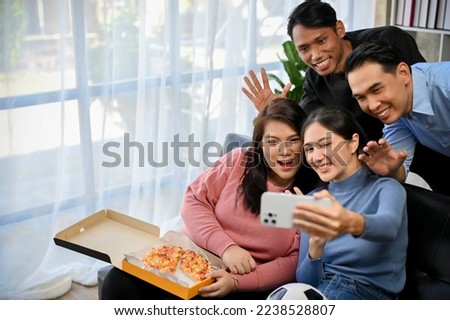 Group of diversity Asian friends taking a photo with smartphone together in the party, having fun time together at home.