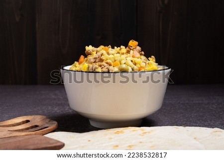 Filling of rice, corn, meat for cooking Mexican food tacos in a white bowl.