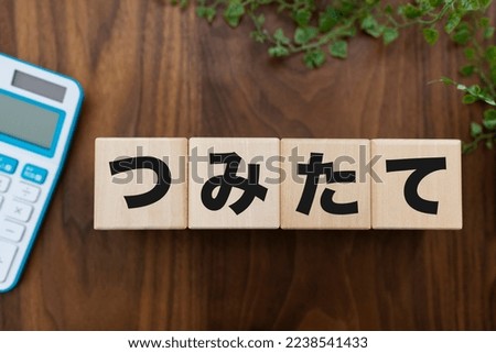 Wooden block with accumulation written on it , Japanese translation " tsumitate "