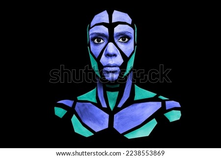 Portrait of a human with creative art makeup posing in the studio. Shape of colored polygons on beautiful face. Parts of face isolated on black background.