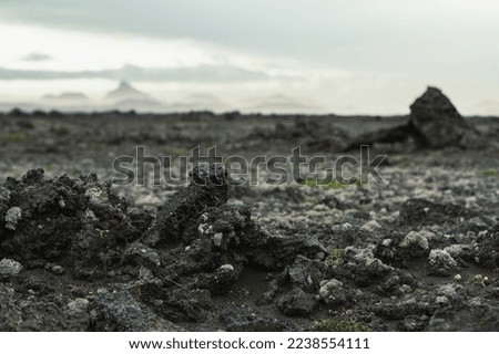 Close up dark wet ground concept photo. Dirt of arctic valley. Front view photography with distant mountain on background. High quality picture for wallpaper, travel blog, magazine, article