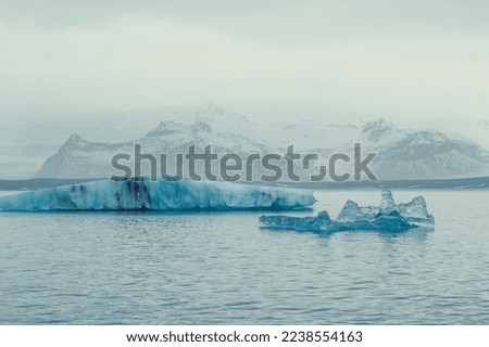 Ice pieces in northern sea landscape photo. Beautiful nature scenery photography with large mountains on background. Idyllic scene. High quality picture for wallpaper, travel blog, magazine, article
