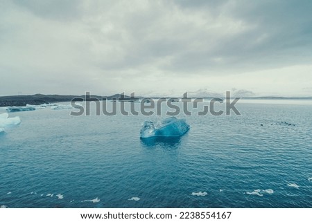 Blue glacier in sea water landscape photo. Beautiful nature scenery photography with cloudy sky on background. Idyllic scene. High quality picture for wallpaper, travel blog, magazine, article