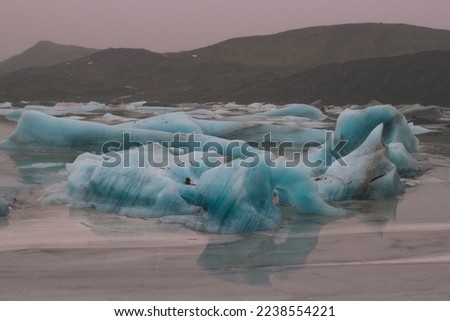 Irregular ice pieces in valley landscape photo. Beautiful nature scenery photography with mountain on background. Idyllic scene. High quality picture for wallpaper, travel blog, magazine, article