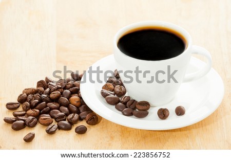 Coffee beans in cup on table