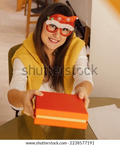 Happy young woman packs gift and taking a selfie at Christmas holiday at home. Beautiful female posing for Christmas selfie. Lifestyle photo