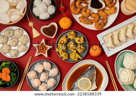 Chinese new year festival table over red background. Traditional lunar new year food. Flat lay, top view Royalty-Free Stock Photo #2238588339