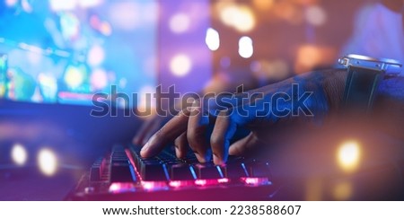 Banner keyboard for game blur bokeh background soft focus. Hand of Professional African cyber video gamer, neon color.