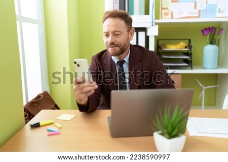 Middle age man business worker using laptop and smartphone at office