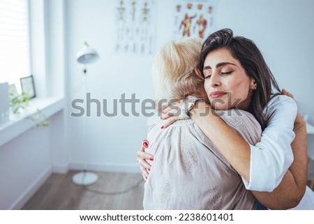The elderly woman enjoys an embrace from her favorite home healthcare nurse. Medical care, young female doctor hugging patient. Empathy concept. Elderly woman hugging caregiver Royalty-Free Stock Photo #2238601401