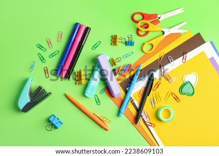 Set of different stationery on green background