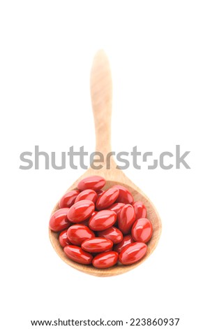 Pills drug on wooden spoon isolated on white background