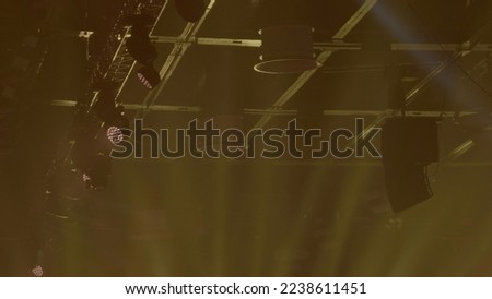 Colorful projectors hang on the metal construction on the ceiling. Stock footage. Spotlights shimmering in the concert hall, automated lighting stage technology.