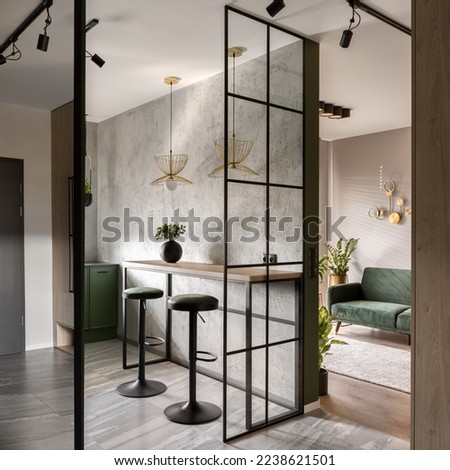 Modern apartment with industrial style reinforced glass wall and ceiling lights, concrete wall and stylish furniture Royalty-Free Stock Photo #2238621501