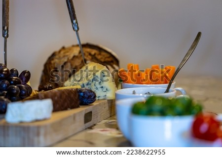 A cheeseboard, bread and nibbles at a party Royalty-Free Stock Photo #2238622955