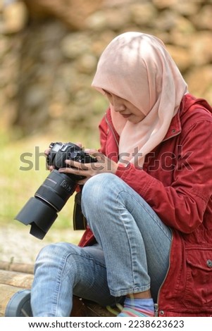 a woman checks the image on the camera
