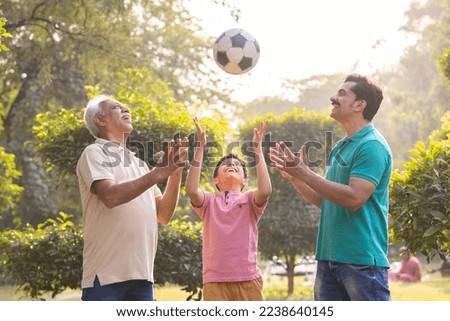 Three generation family having fun while playing with ball at park. Royalty-Free Stock Photo #2238640145