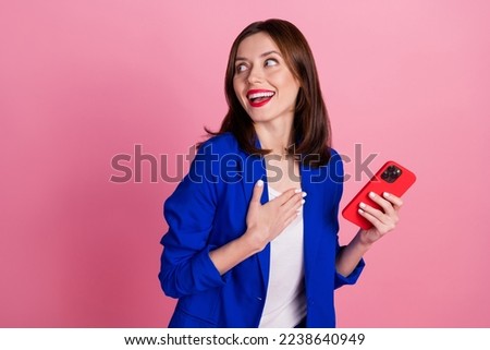 Photo of gorgeous positive lady hold gadget wear trendy clothes hand chest interested look empty space isolated on pink color background