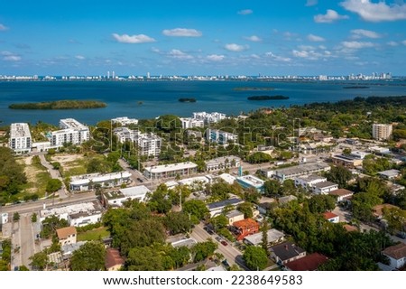 Aerial shot of Upper East Side residential neighborhood
in Miami, lush vegetation is seen, modern buildings, luxury houses, urban skyline, blue sky, street with cars Royalty-Free Stock Photo #2238649583