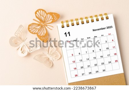 November 2023 desk calendar for the organizer to plan and reminder and butterfly paer on yellow background.