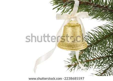 Christmas bell with bow hanging on fir tree branch against white background