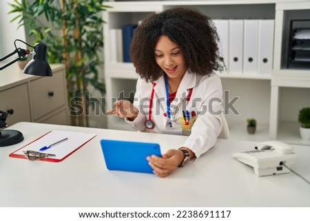 Young african american woman wearing doctor uniform having teleconsultation at clinic