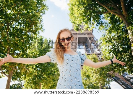 Young beautiful and elegant  woman in blue dress near the Eiffel tower in Paris