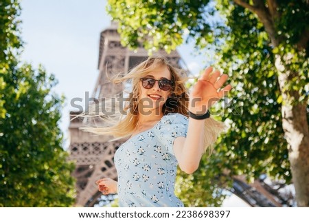 Young beautiful and elegant  woman in blue dress near the Eiffel tower in Paris