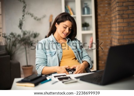 Beautiful young pregnant woman looking at ultrasound pictures of her baby. Businesswoman in office.