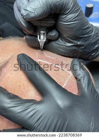 Performing hair micropigmentation procedure First session Royalty-Free Stock Photo #2238708369