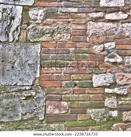 Italia, Perugia, estate 2022. Frammento di muro in mattoni e grandi pietre. Sul muro sono visibili tracce di vernice blu.